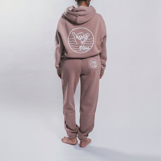 Woman wearing the hazy pink Gooder Hoodie and matching sweatpants