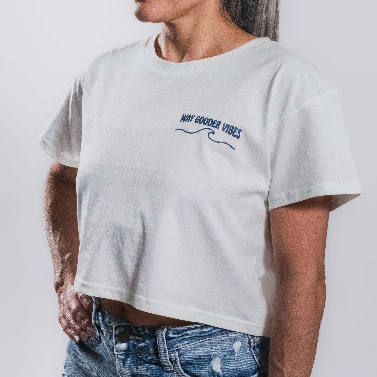 Woman wearing the natural Golden Horizon crop tee showing the cropped fit